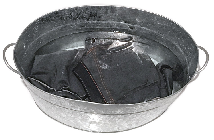 soaking raw denim jeans in a tub